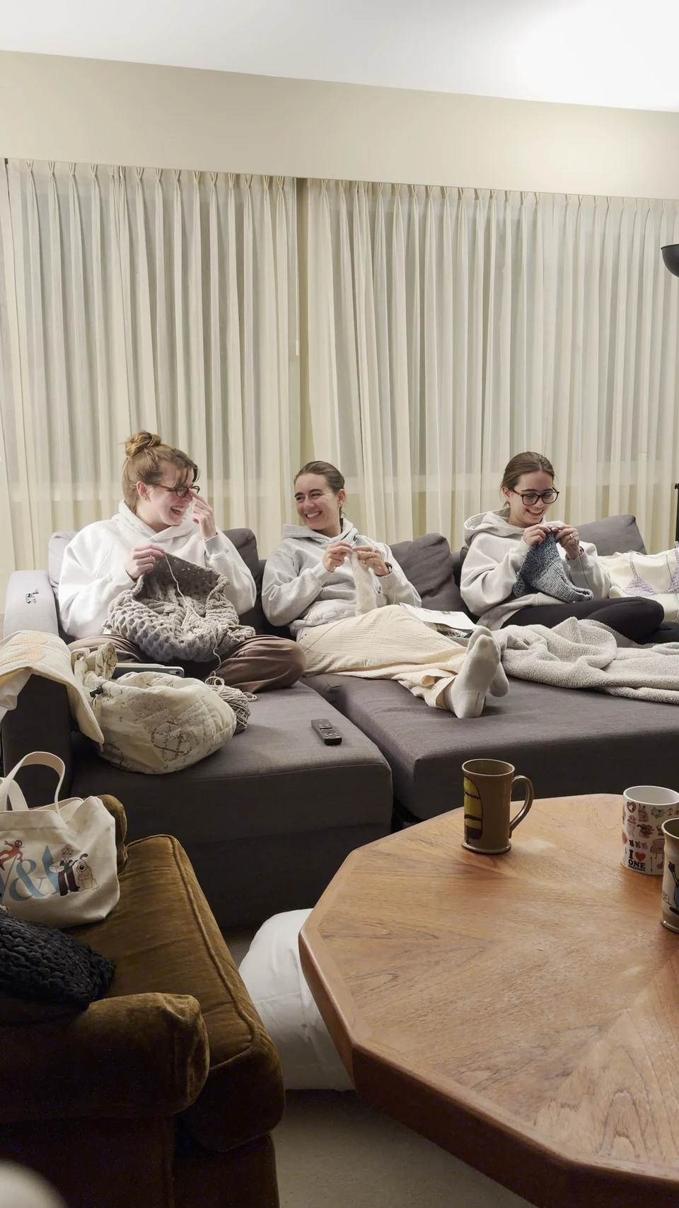 3 people knitting on a couch